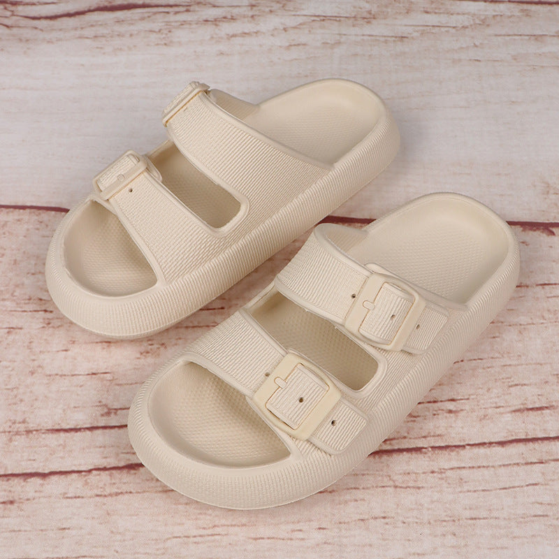 Beige sandals with buckle straps on a wooden surface