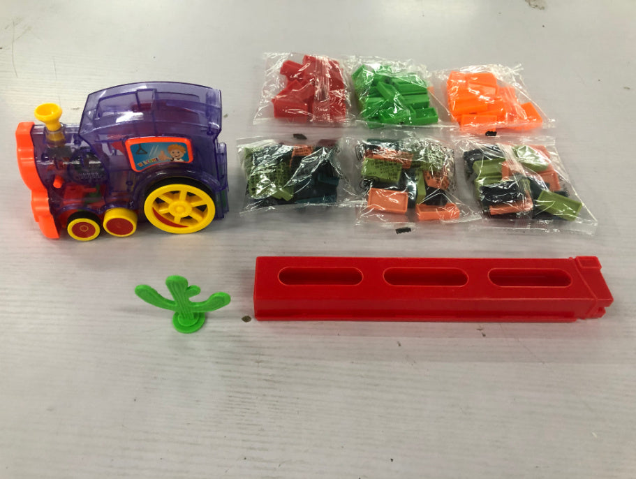 Toy train set with plastic bags containing small toys on a white surface