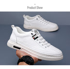 White sneakers held by a person against a gray background