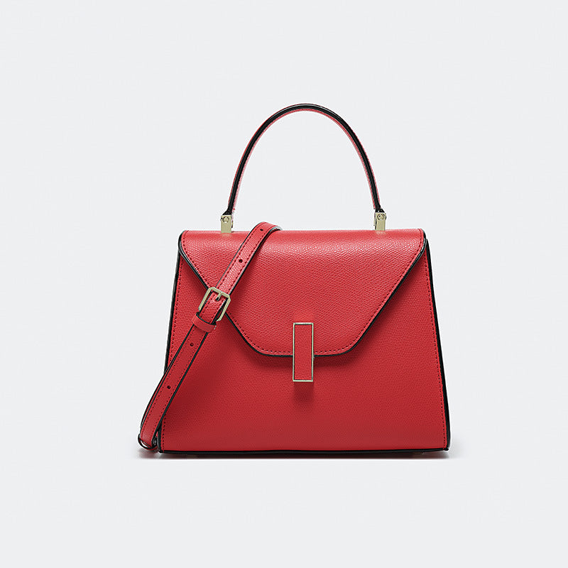 Red handbag with gold accents on a light gray background