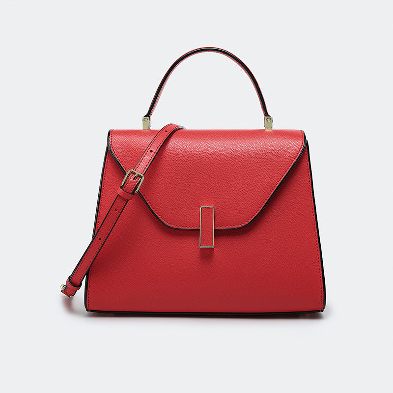 Red handbag with gold accents on a light gray background