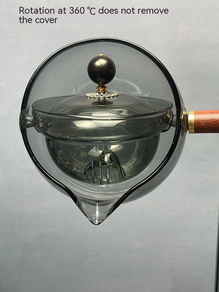 Glass teapot with a lid on a gray background