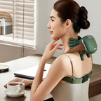 Woman using a green neck and shoulder massager at a desk with a cup of coffee.