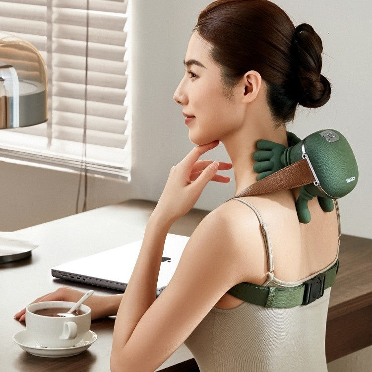 Woman using a green neck and shoulder massager at a desk with a cup of coffee.