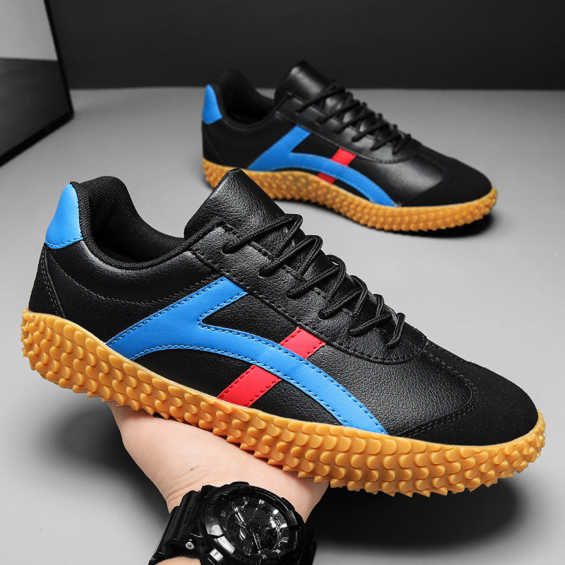 Black sneakers with blue and red accents on a gray surface