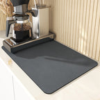 Gray mat on a kitchen counter with a coffee maker in the background
