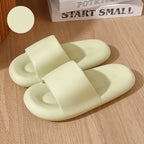 Pair of light green slippers on a wooden surface with a book titled 'Start Small' in the background.