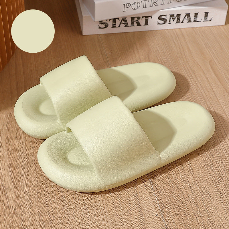 Pair of light green slippers on a wooden surface with a book titled 'Start Small' in the background.