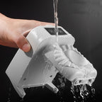 Hand holding a white dumpling maker with water flowing out against a black background