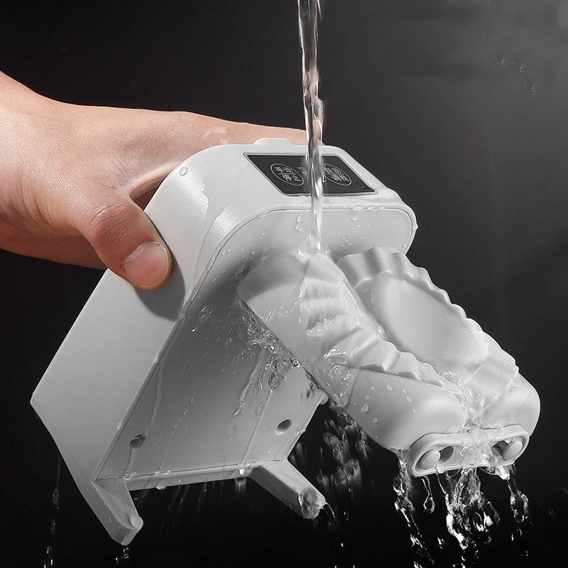 Hand holding a white dumpling maker with water flowing out against a black background