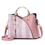 Pink handbag with a heart-shaped keychain on a white background