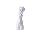 White ceramic sculpture of a child on a white background