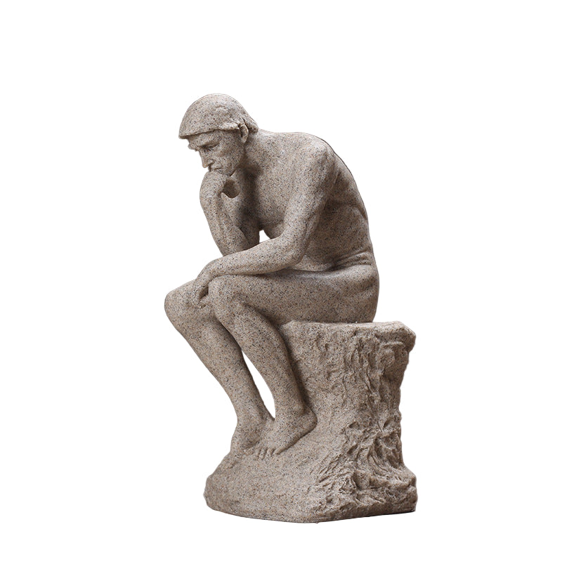 Stone sculpture of a thinker on a wooden surface with a dark background