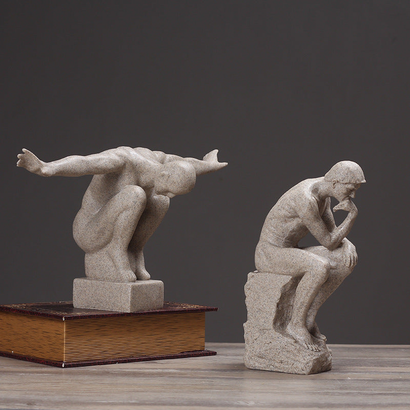 Two stone sculptures on a wooden surface with a dark background