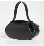 Black handbag with a strap on a light gray background