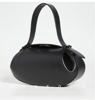 Black handbag with a strap on a light gray background