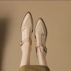 Beige shoes with green buckles on a beige background