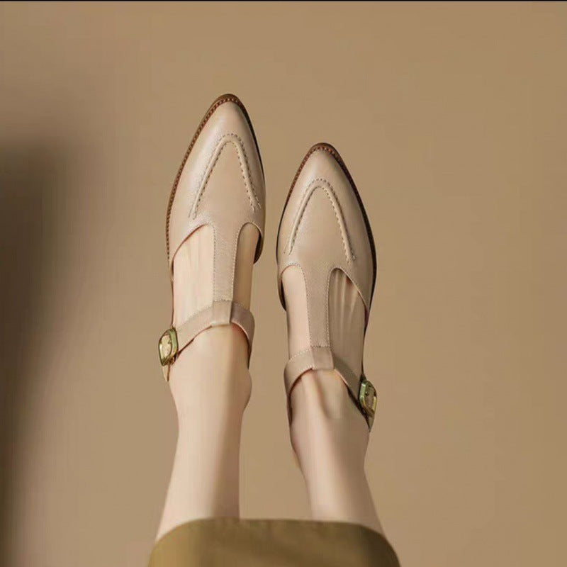 Beige shoes with green buckles on a beige background