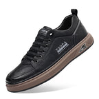 Black leather sneaker with brown sole on a white background