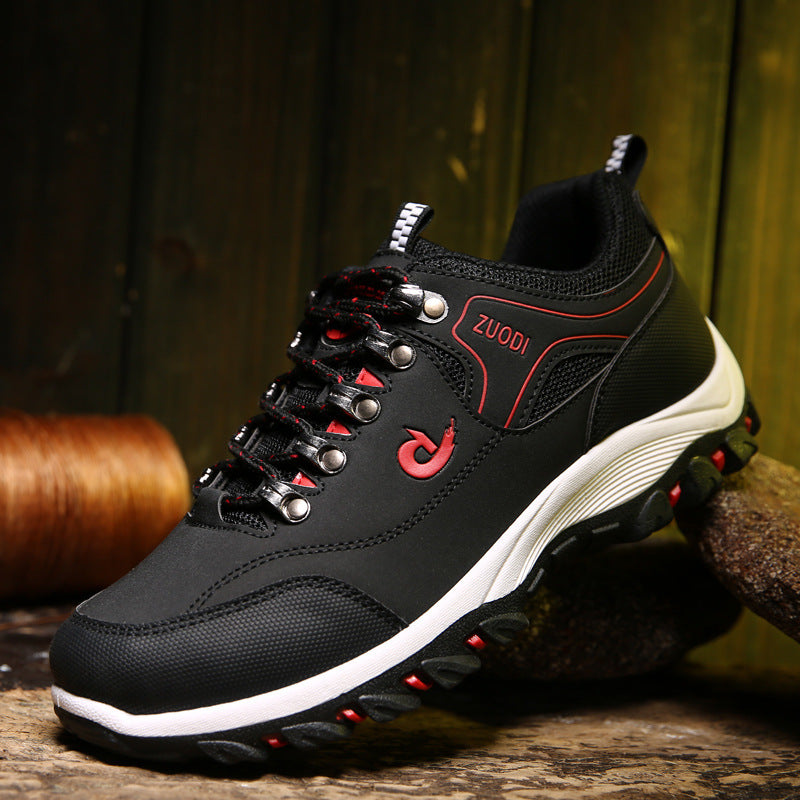 Black hiking shoe with red accents and 'Zuodi' branding on a wooden surface.