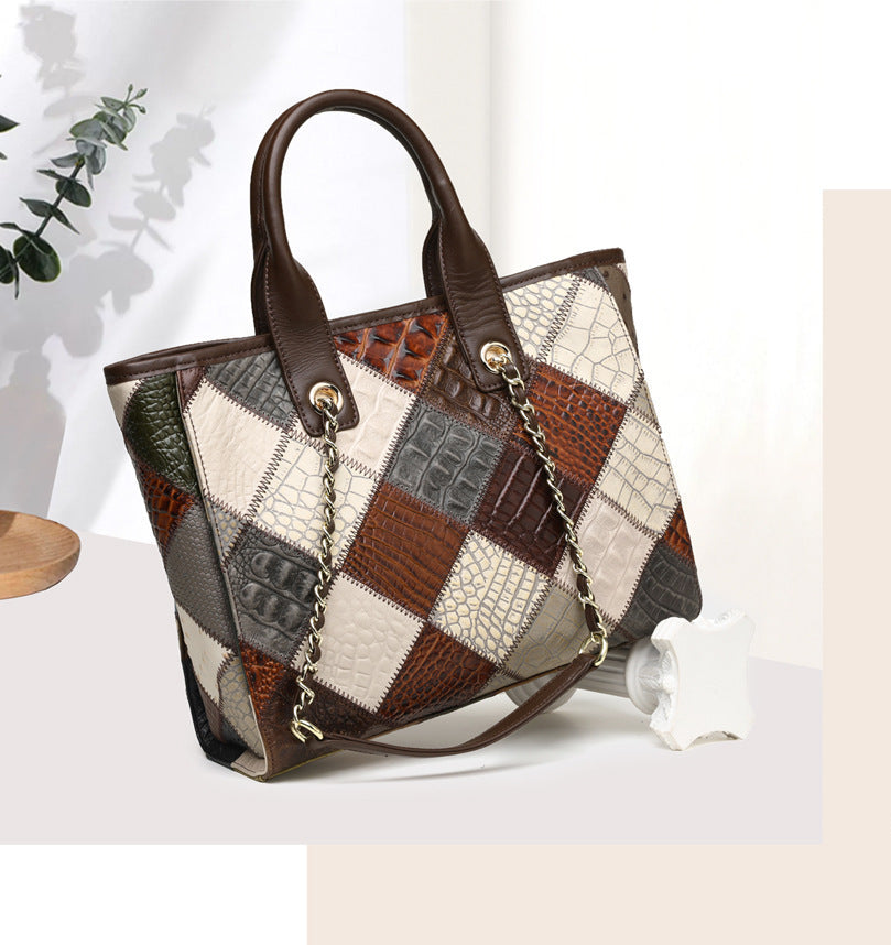 Patchwork handbag with a chain detail on a white surface