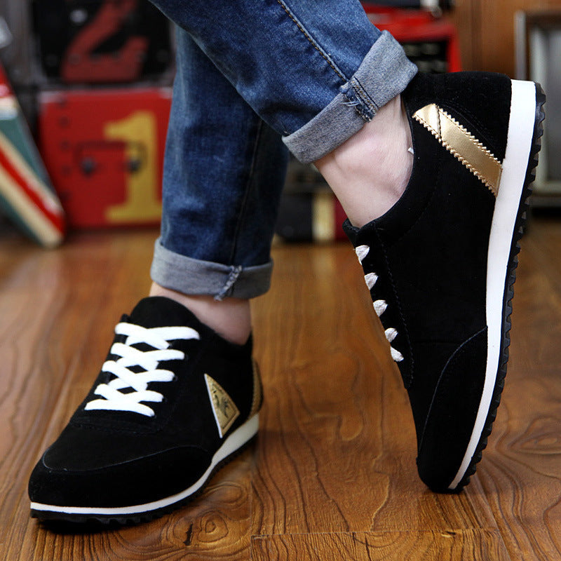 Black sneakers with white soles worn on a wooden floor