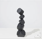 Stack of black textured stones on a white background