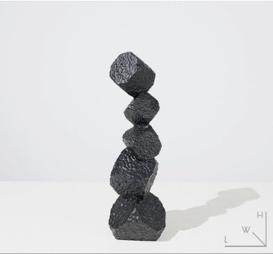 Stack of black textured stones on a white background