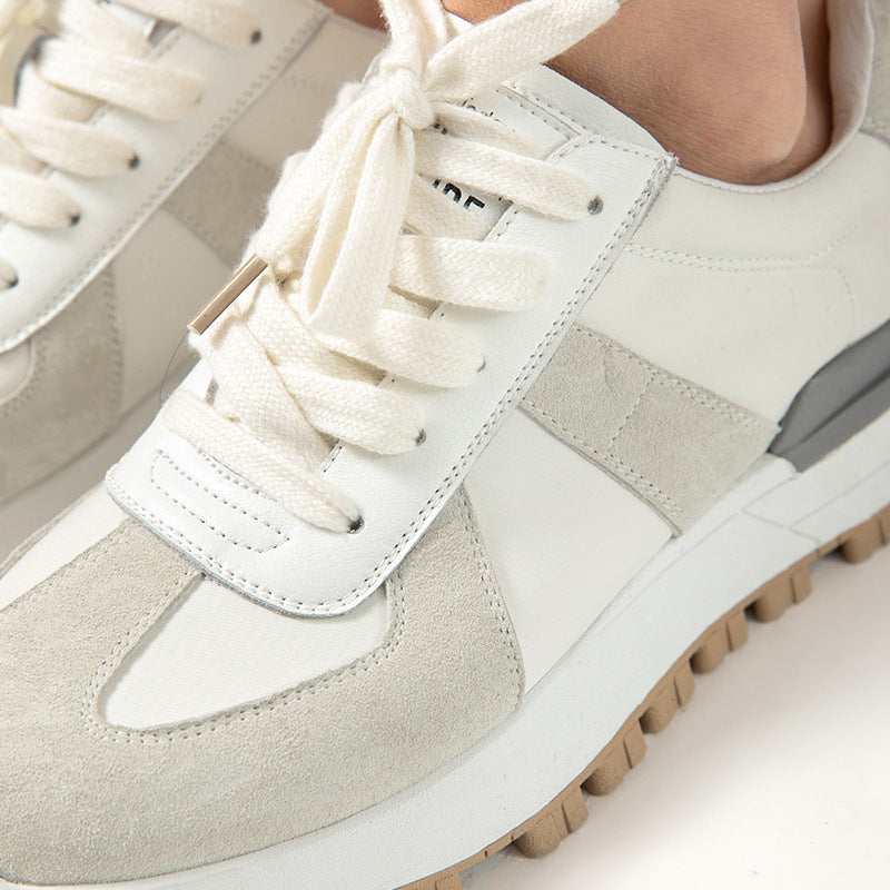 Close-up of a pair of light gray and white sneakers with white laces.