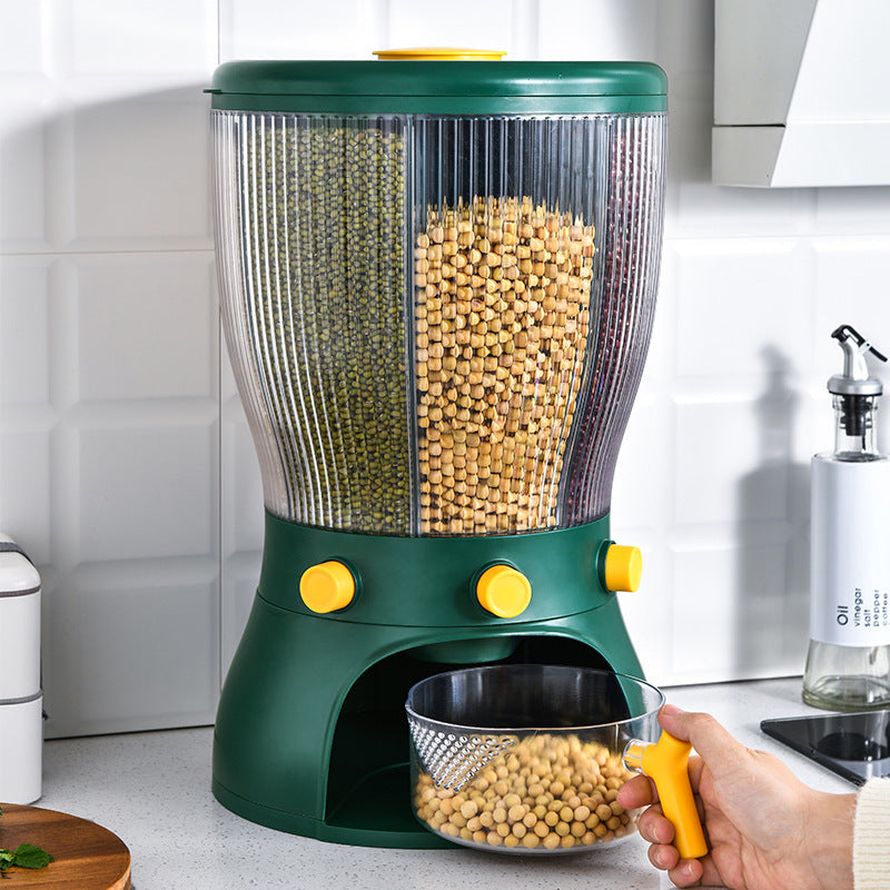 Green pet food dispenser with a clear container filled with kibble, held by a hand in a kitchen setting.