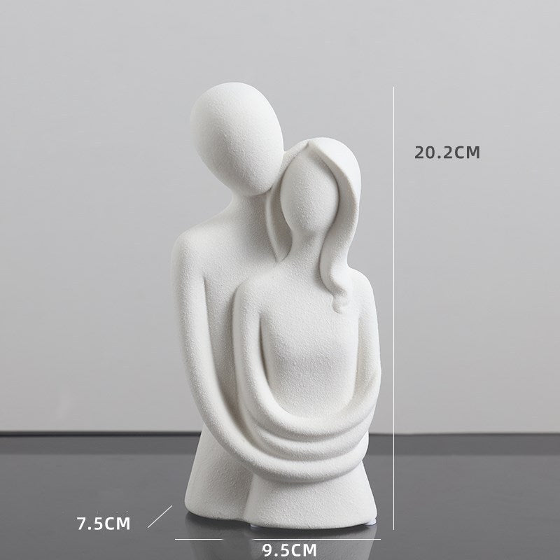 White abstract sculpture of two figures embracing with measurements on a gray background