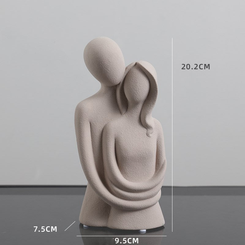 Abstract sculpture of two figures embracing with dimensions indicated on a gray background