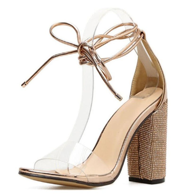 Beige high-heeled shoe with clear perspex sole and woven heel on a white background