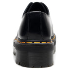 Black leather shoe with yellow stitching on a white background
