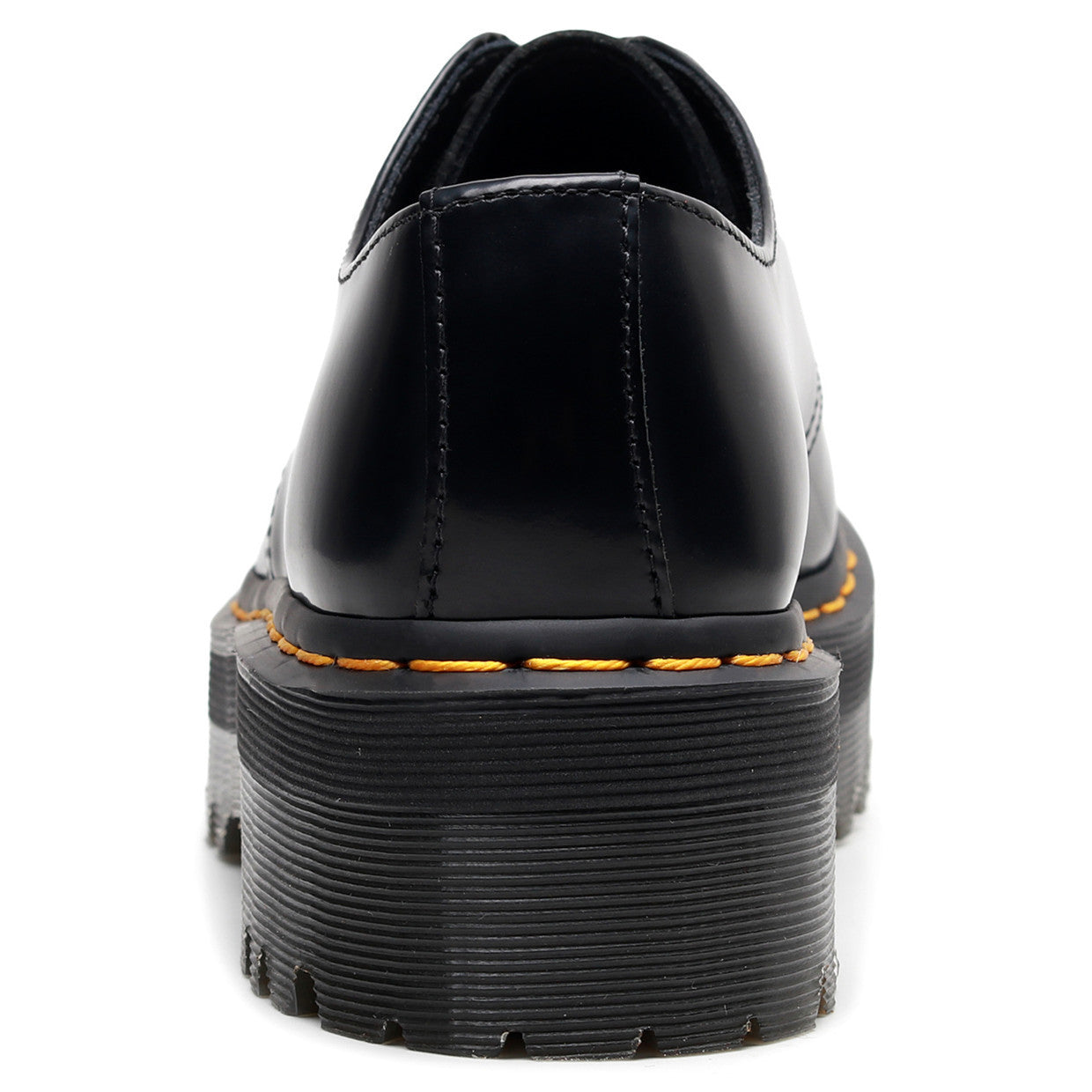 Black leather shoe with yellow stitching on a white background