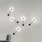Modern wall light fixture with multiple black lampshades on a white wall.