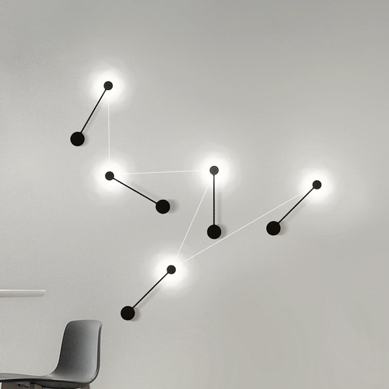 Modern wall light fixture with multiple black lampshades on a white wall.