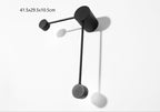 Black wall-mounted coat rack with three hooks on a white background