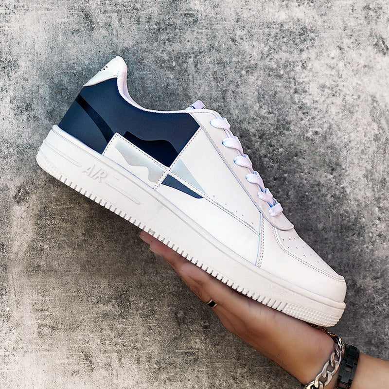 White sneaker with navy accents held against a textured gray background