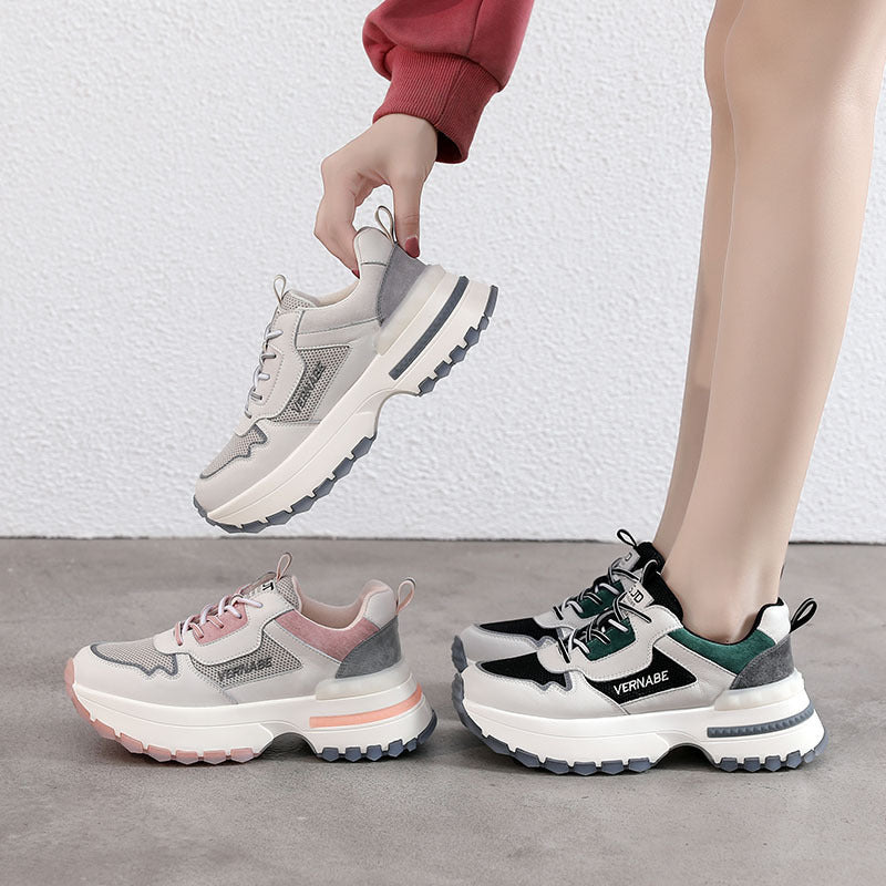 Three pairs of chunky sneakers with different color schemes on a gray floor.