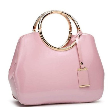 Pink handbag with gold accents on a white background