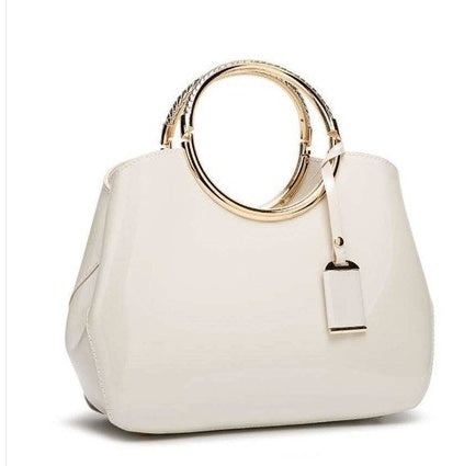 White handbag with gold handle on a white background