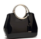 Black handbag with gold ring handle on a white background