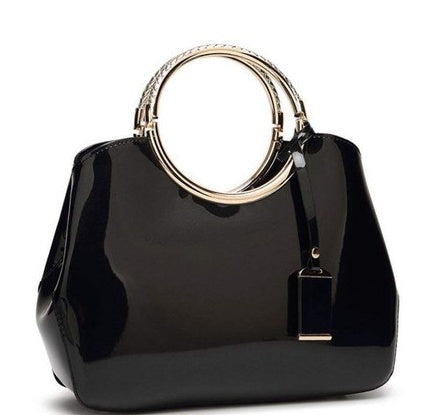 Black handbag with gold ring handle on a white background