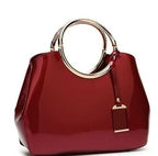 Red handbag with gold handle and clasp on a white background