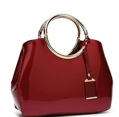 Red handbag with gold handle and clasp on a white background