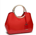 Red handbag with gold handle and clasp on a white background