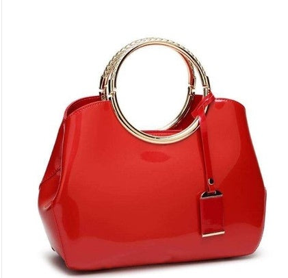 Red handbag with gold handle and clasp on a white background