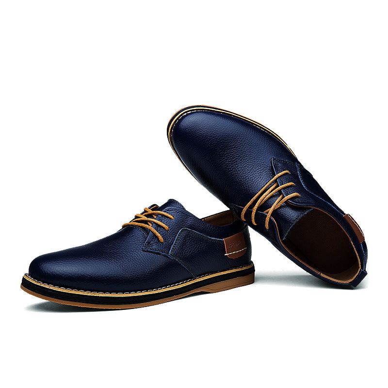 Pair of navy blue leather shoes with brown soles and laces on a white background