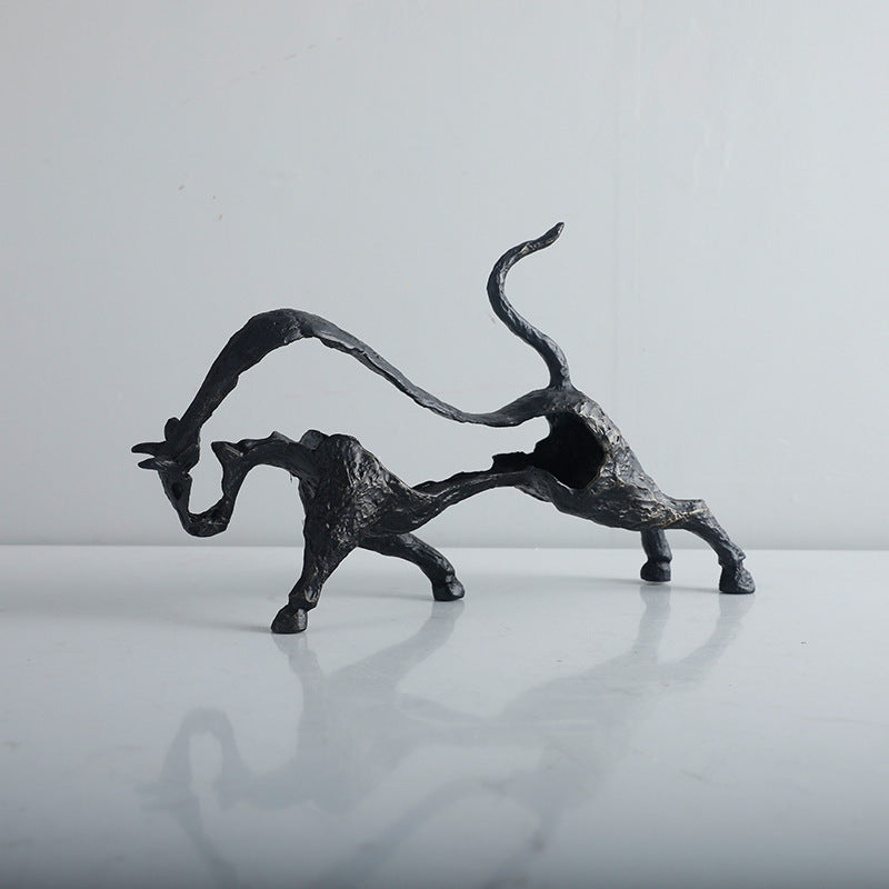 Bronze sculpture of a dynamic animal figure on a reflective surface with a neutral background